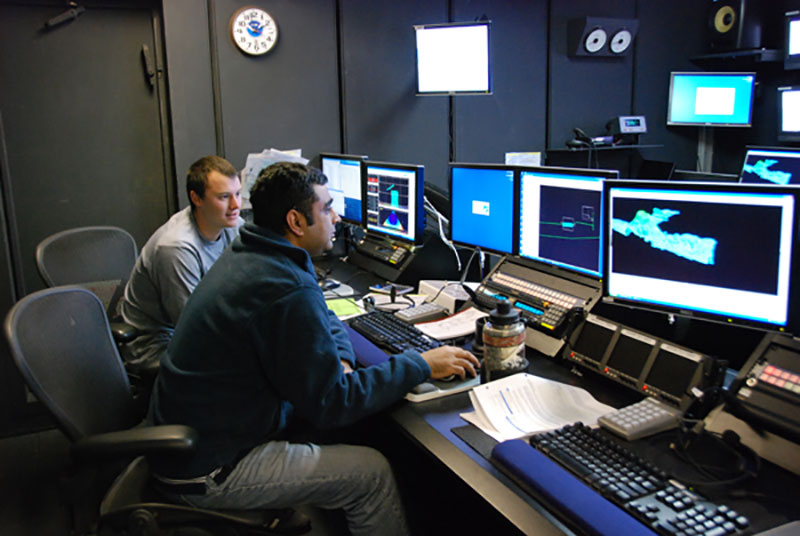 Physical scientist Mashkoor Malik (right) and intern David Armstrong (left) edit multibeam data using the software CARIS during the shakedown mission.