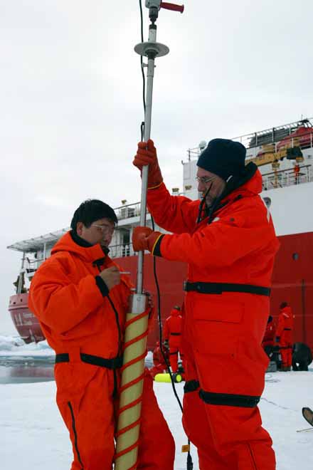 Gerry Plumbley and Qing Zhang prepare to drill an ice core.