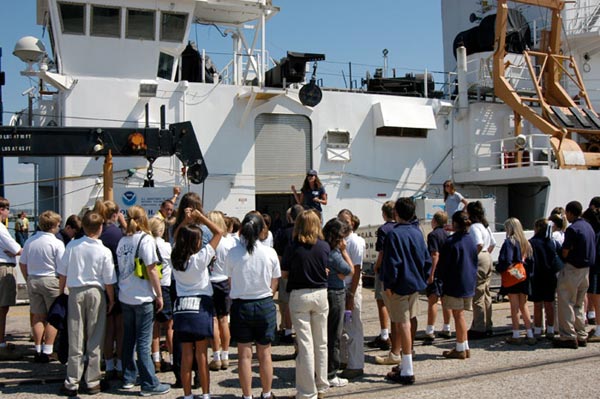 Students and teachers gather on the dock