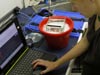 Alison prepares the spectrometer, an instrument that measures the wavelengths in light, to study the absorption and reflectance properties of the fishs fluorescent lens.