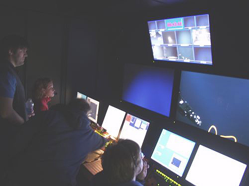 Kari Heinonen, Mike McKee and Dr. Scott France watch from inside the control van as ROV Hercules manipulator arm Predator takes a sample from Bear Seamount