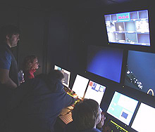 Kari Heinonen, Mike McKee and Dr. Scott France watch from inside the control van as ROV Hercules manipulator arm Predator takes a sample from Bear Seamount.