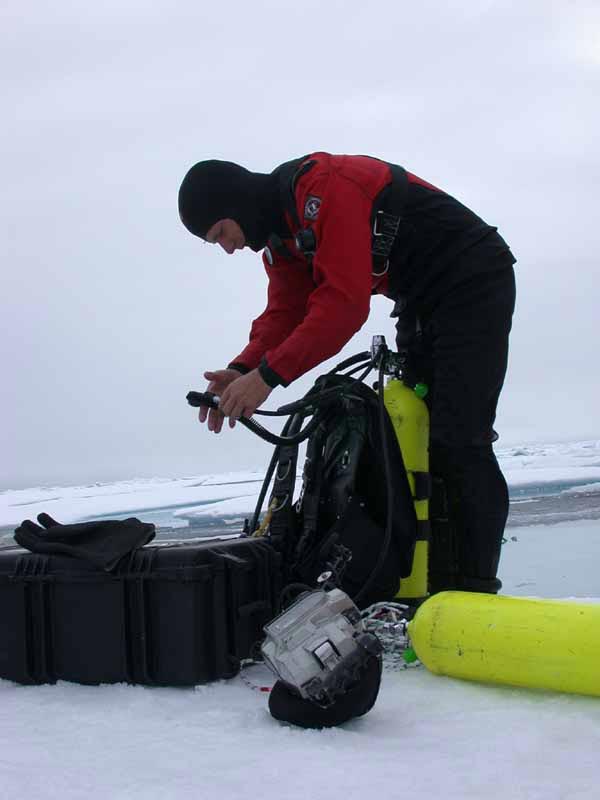 Ice diver Wayne Smith checking his gear before an ice dive. 