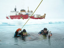 Ice Divers Katrin Iken and Elizabeth Calvert are about to descend through a small hole in the ice.