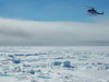 The North Slope Borough Department of Search and Rescue (NBSAR) helicopter approaches the HEALY over ice-covered waters.