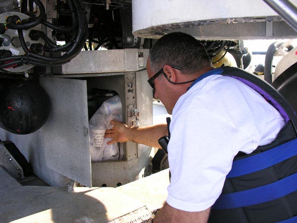 Submersible pilot Hugo Marrero places Styrofoam cups in the battery box of the Johnson-Sea-Link submersible
