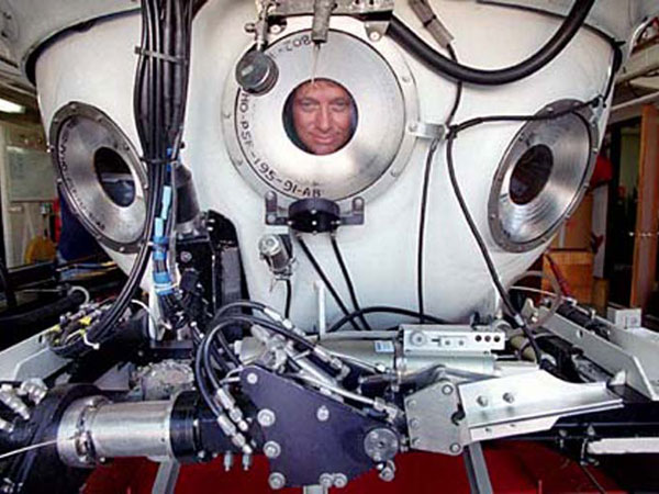 One of the Pisces crew looking out the porthole of the submersible.