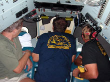 The pilot looks out the center viewport and the co-pilot and observer look out the other two windows.  This view is looking down through the open hatch before a dive.