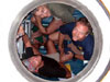 Chief Pilot Terry Kerby (lower left)looks up through the hatch from inside the Pisces V submersible.