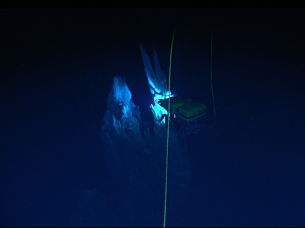 Ghostly scene of Hercules viewed from its tethered companion vehicle Argus as it approaches one of the carbonate spires of the Lost City Hydrothermal Field.   Courtesy of IFE, URI-IAO, Lost City science party, and NOAA.