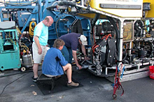 Timothy Shank of the Woods Hole Oceanographic Institution, David Lovalvo of the Institute for Exploration (IFE), and David Wright of IFE work on modifications to the ROV Hercules.