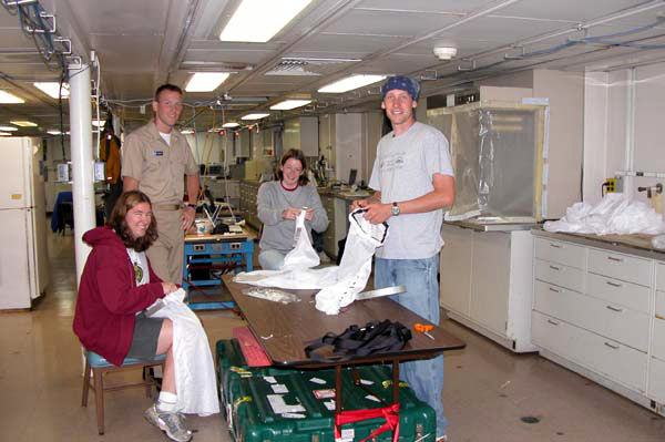 Kate Buckman of the Woods Hole Oceanographic Institution, Sarah L’Heureux of the University of Delaware, and Alex Gagnon of the California Institute of Technology craft nets to be used in collecting specimens of coral fossils, while Junior Officer, Ensign James Brinkley looks on. 