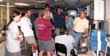 The science party consults with Allen Gontz of the University of Massachusetts (seated) and his mutlibeam data in coming to a decision concerning the next dive site.