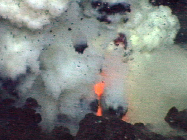 Glowing red lava jetting out of the vent at NW Rota-1 Brimstone Pit.