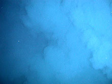 A large plume of white fluid slowly rises out of one of the craters at the summit of Daikoku.