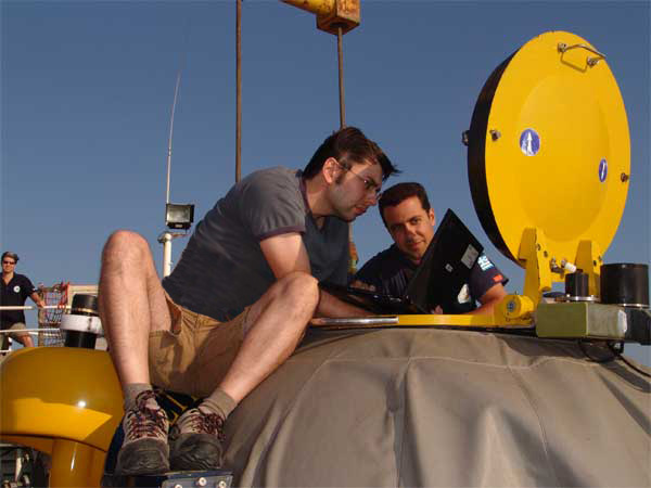 Ryan Eustice and electrical engineer Aggelos Malios sync the time on two laptops.