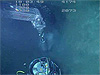 The submersible pilot grabs one of corers with the manipulator and pushes it into the sediment.