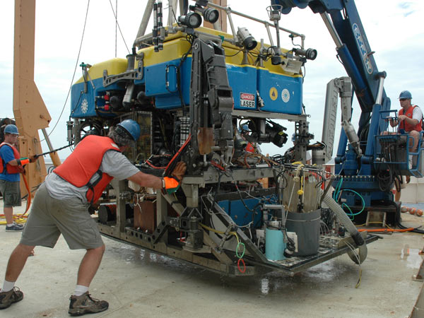 Jason team members James Pelowski, Casey Agee, and Alberto Collasius position the ROV in preparation for launch.
