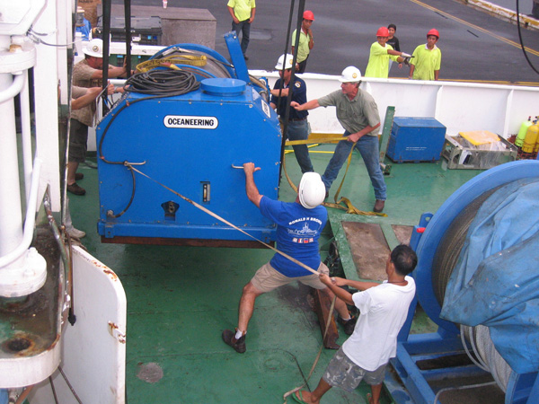 The barge-mounted crane lowers the six-ton winch for the ROV