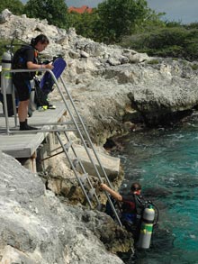 Preparing to conduct underwater video transects, sientist enter the water from a platform at Oil Slick Leap dive site.