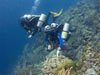 Expedition members descending to the deep reef using trimix technical diving.'