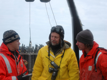 Aleksey Ostrovskiy, center, translates between Chief of Expeditions Vladimir Bakhmutov, left, and graduate student Jared Weems, right.