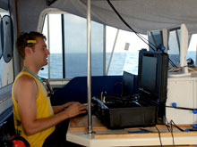 Playing a real-life video game: Todd Hallenbeck focuses on the live video feed while piloting the ROV beneath the surface of Bermuda’s waters in search for caves.