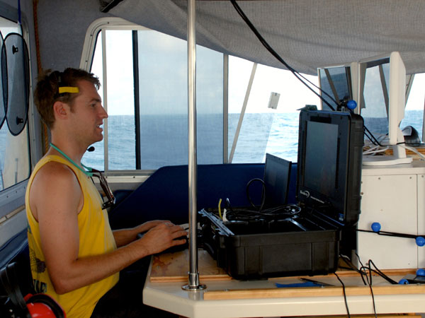 Playing a real-life video game: Todd Hallenbeck focuses on the live video feed while piloting the ROV beneath the surface of Bermudas waters in search for caves.   