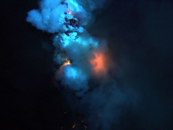 An area on the summit of the West Mata Volcano erupts. At the bottom of the image is magma flowing down the slope of the volcano. 