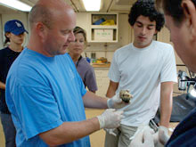 Dr. Tim Shank discusses a seafloor specimen with other members of the science party. 