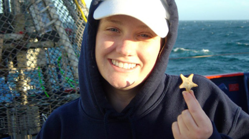Ashlee Henig and her new friend “Patrick” pose together after the starfish was rescued from the scavenging biologists.