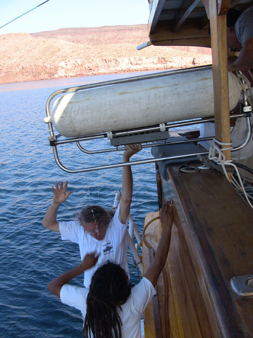 Michael Faught and Jose Juan (JJ) Puebla help load the float for a piece of marine sonar equipment back onto the boat.