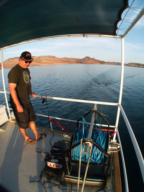 Loren Davis inspects the motorized winch that was used to pull the towfish of the side scan sonar system.