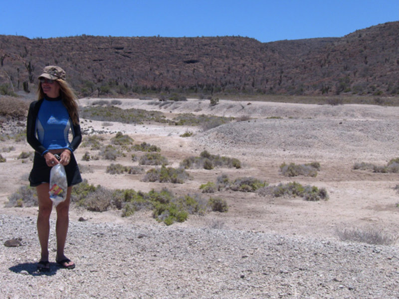 Josiane Dalcourt stands beside a 125,000 year-old exposed relic coral reef. Pieces from this reef have been found in near-by archaeological sites where the site inhabitants used sharpened pieces of coral as tools.