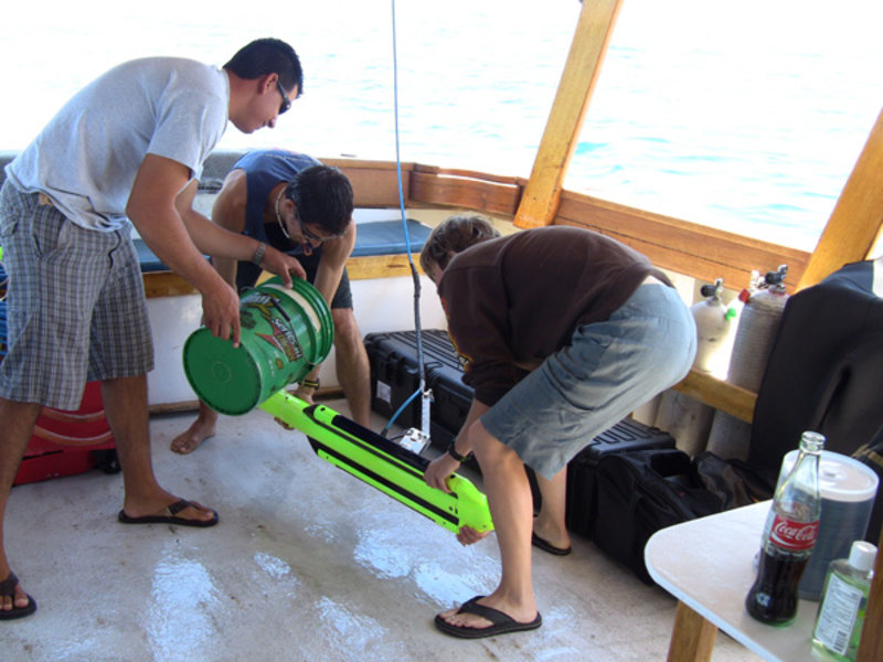 Members of the research crew wash off the side scan sonar towfish after it was loaded back onto the boat.