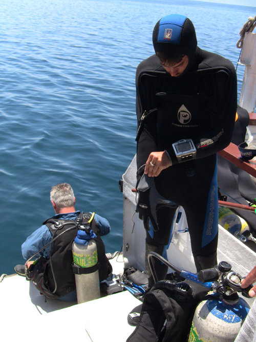 Kaya Chotard (standing) and Loren Davis suit up as they prepare to conduct underwater survey.
