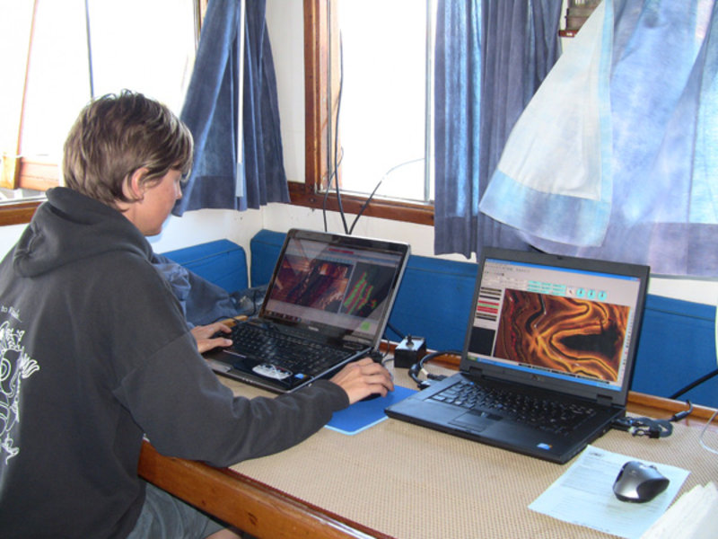 Amy Gusick monitors the images from the side scan sonar to select locations that will be surveyed during the diving phase.