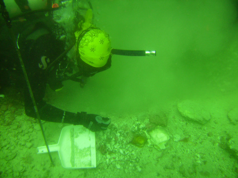 Amy Gusick collects samples from a test pit 60 ft. below sea level.