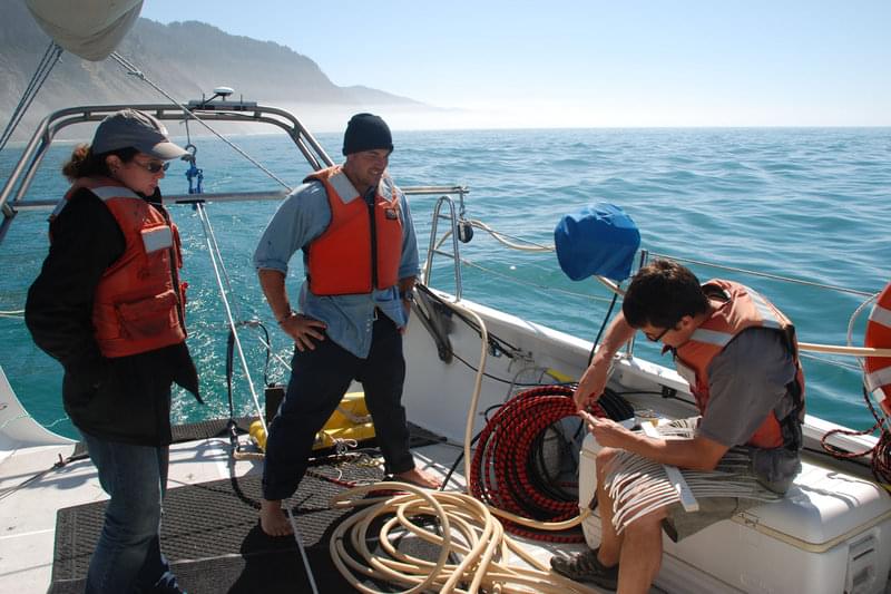 Jackson Currie from USGS trims the ends of the sparker while Bran Black and Tim Kane from OSU observe. Salt water erodes the electrodes at the ends of the sparker and they must be trimmed every few hours to ensure accurate data collection.