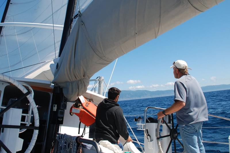 <em>Baylis</em> Captain Mark Kocina handles the wheel while First Mate Sam Kesten watches.