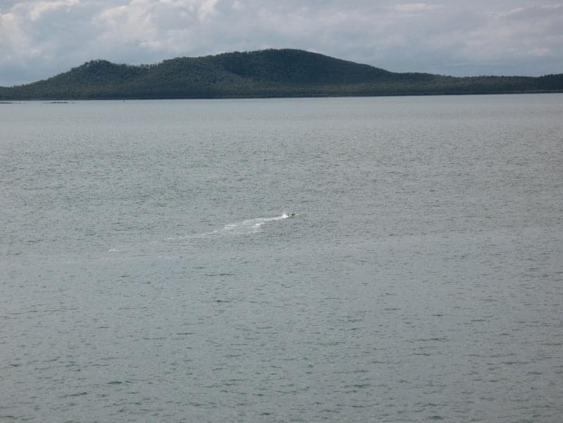 The AUV is under remote control, swimming a safe distance from the ship, just before it is commanded to begin its mission and dive below the surface.