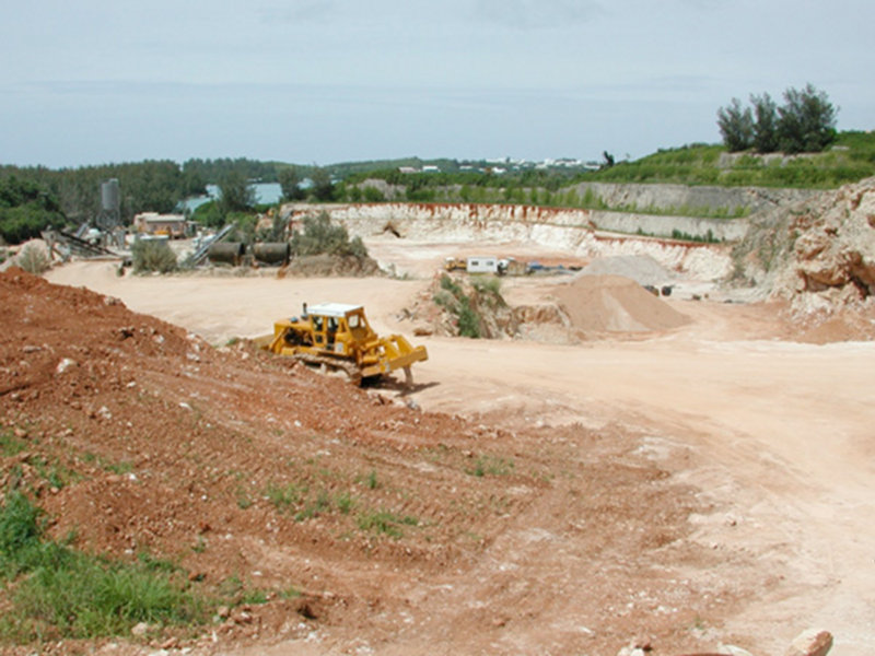 Limestone quarry in Bermuda with remnant cave in center of cliff in the process of being destroyed.