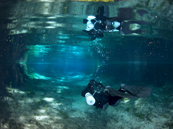 Side mount diver swimming.