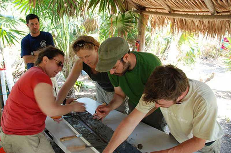 Trish Beddows, Beverly Goodman, Wes Patterson and Dan Leonard work together to open up one of the first cores pulled from the sediments near Vista Alegre, while Dominique Rissolo looks on. Trish and Beverly will analyze samples from the cores to look back at the site’s prior ecology, and water chemistry.