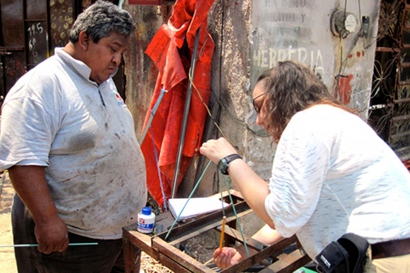 Freddy Flores, a welder in Kantuniklin, pays close attention as Trish explains the basic design and concept of creating a metal tripod to pull cores out of the mud. Not only did Freddy create a collapsible and functional tripod, he also surprised the members of the expedition with its pink paint job.