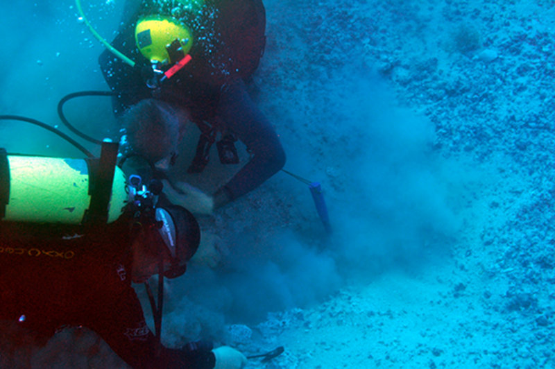 In 2009, the Submerged New World team investigated several areas that potentially contain deposits from the Late Pleistocene. This year, the team will return to some of these locations to investigate them more thoroughly. Her Co-principal Investigator C. Andrew Hemmings and Nicolas Alvarado dig a hole through old coral that covers the buried — and ancient — Suwannee River, about 75 miles offshore.
