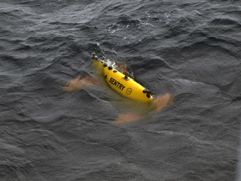 Once the ship comes close enough alongside, Al uses a remote control system similar (in principle) to that of a remote control car to drive Sentry in close beside the ship.