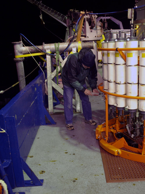 Marv collecting samples from the CTD-rosette using a plastic syringe.