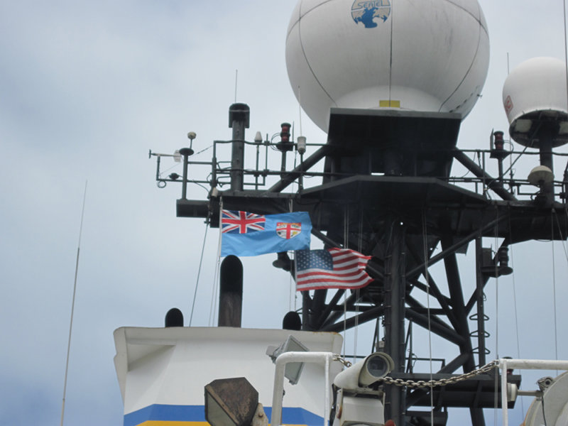 The Fijian and U.S. flags fly high atop the mast of the R/V Roger Revelle while in port in Suva, Fiji.