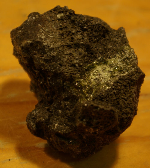 A huge (>1cm long) crystal of the mineral clinopyroxene from a very fresh volcanic rock sample.